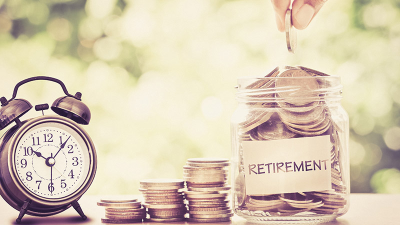 Hand-putting-Coins-in-glass-jar